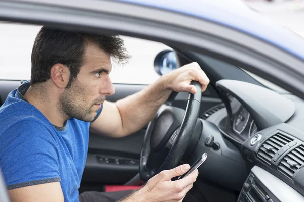 Adam sürüş araba ve holding telefon, tehlikeli kavramı.