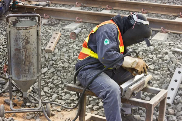 Trabajadores reparan las vías ferroviarias con chorro de arena . — Foto de Stock