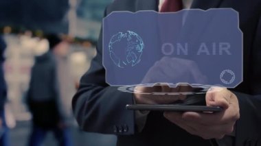 Unrecognizable businessman uses hologram on smartphone On Air. Man in jacket with holographic screen on background of entrance to the airport or train station