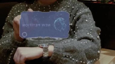 Unrecognizable woman working with HUD hologram of a smart watch with text New Petition. Female hands with future holographic technology in wrist watches