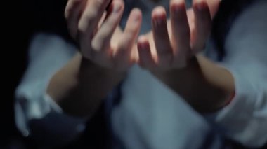 Female hands show a round conceptual hologram with text WiFi 6. Unrecognizable woman in ashen white on a black background with future holographic technology