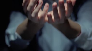 Female hands show a round conceptual hologram with text You Win. Unrecognizable woman in ashen white on a black background with future holographic technology