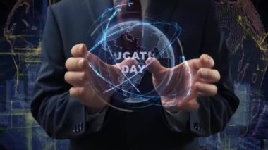 Male hands activate a conceptual holographic text Education day. Businessman in a suit with a hologram of planet Earth on a background of a futuristic wireframe city