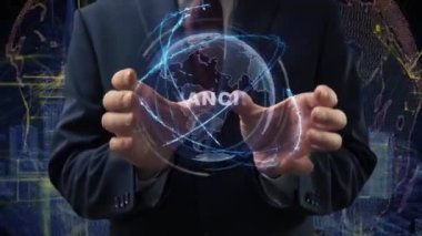 Male hands activate a conceptual holographic text Financing. Businessman in a suit with a hologram of planet Earth on a background of a futuristic wireframe city