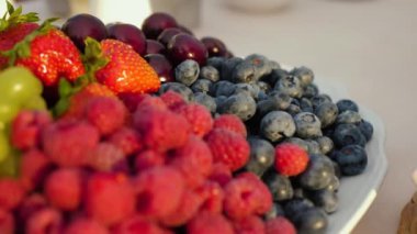 Taze meyve ve meyve tabağı. Yaban mersini, çilek, kiraz, üzüm, yakın çekim