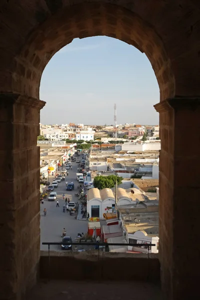 El djem, de skyline van de stad door de bogen van amfitheater — Stockfoto