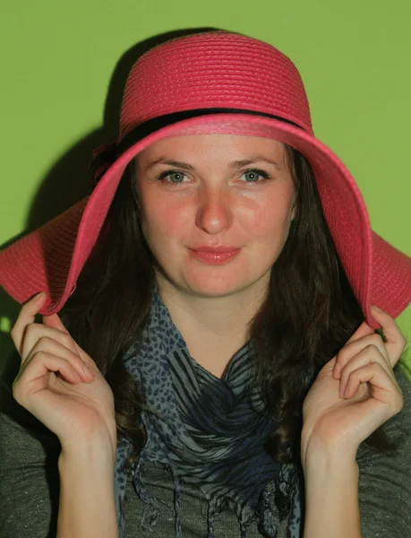 Брюнетка позирует в розовой шляпе — стоковое фото