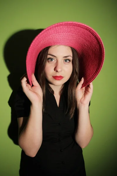 Girl with pink hat on green background — Stock Photo, Image