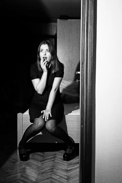 Ritratto di giovane donna seduta sul letto in bianco e nero — Foto Stock