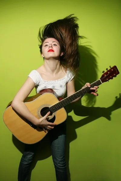 Young brunette wildly playing guitar — Stock Photo, Image