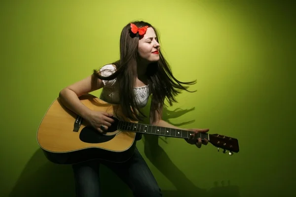 Mujer joven disfruta tocando la guitarra — Foto de Stock