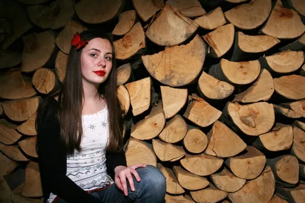 Young woman posing with chopped wood — Stock Photo, Image