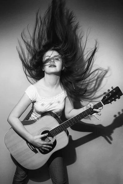 Jovem mulher loucamente tocando guitarra preto e branco — Fotografia de Stock