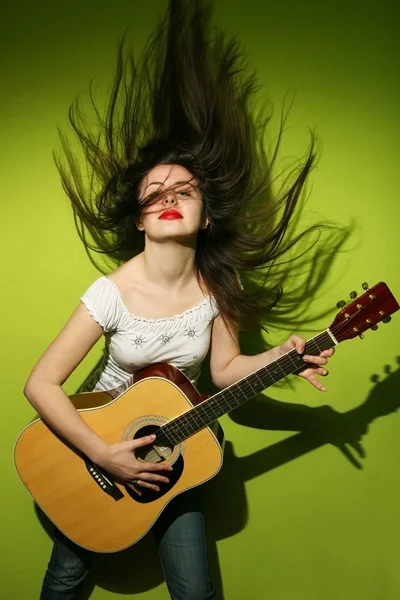 Young woman wildly playing guitar — Stock Photo, Image