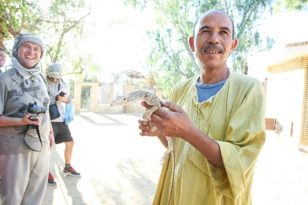 Uomo che tiene il monitor del deserto nello zoo di Tozeur — Foto Stock