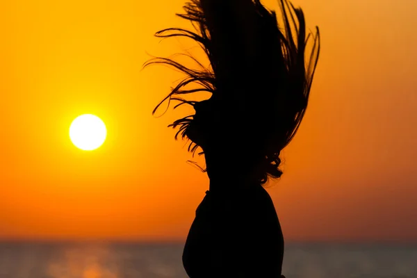 Woman tossing hair at sunset — Stock Photo, Image