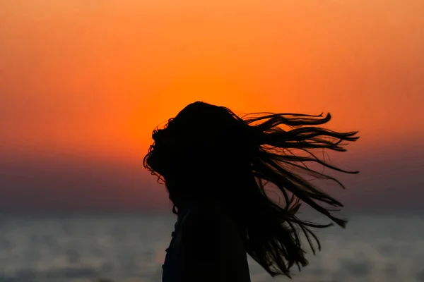 Abstract of woman tossing hair at sunset — Stock Photo, Image