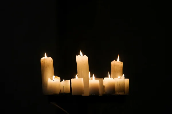 Brennende Kerzen auf schwarzem Hintergrund — Stockfoto