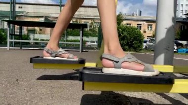 Kız bacak eğitmenine egzersiz yaptırıyor, koşuyor, yürüyor, adım atıyor. Bacaklarını kapat. 