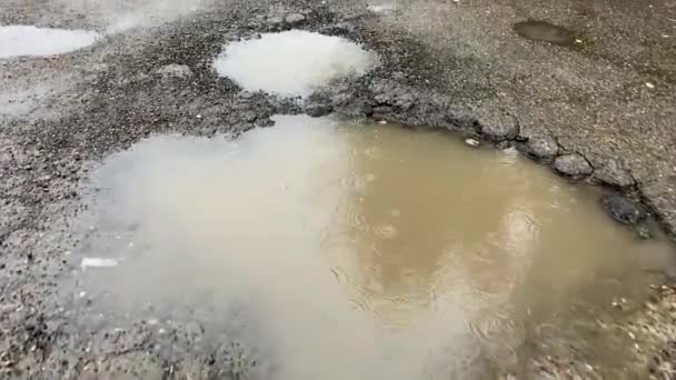 道路は 冬の後破棄されます 道路のピットに水たまり — ストック動画