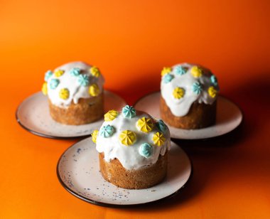 Lezzetli Paskalya yemeği kavramı, turuncu arka planda üç Paskalya pastası.