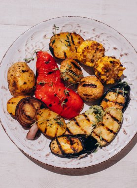 Grilled colorful vegetable : bell pepper, eggplant, mushrooms, potatoes, corn, onions on a plate. Top view with copy space.