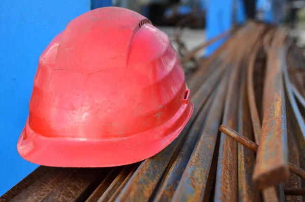 Casco rojo y barras de hierro para la construcción — Foto de Stock