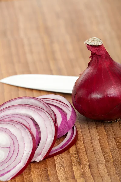 Cebola vermelha na tábua de corte — Fotografia de Stock