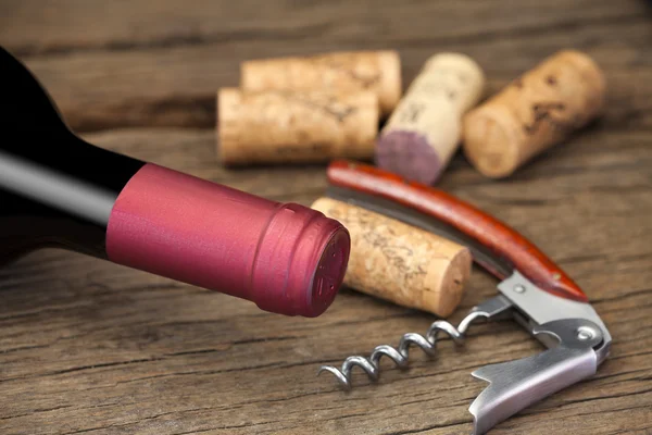 Röd vinflaska med korkskruv — Stockfoto