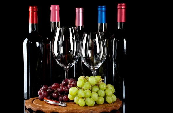 Vinné lahve, vinné sklenice a hrozny — Stock fotografie