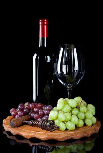 Garrafa de vinho tinto com vidro e uvas — Fotografia de Stock