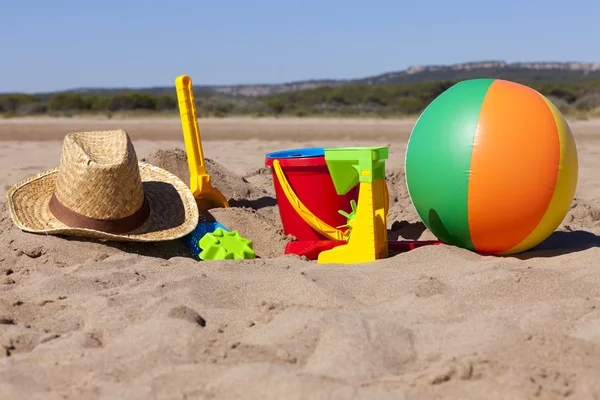 Scena sulla spiaggia con giocattoli e cappello di paglia — Foto Stock