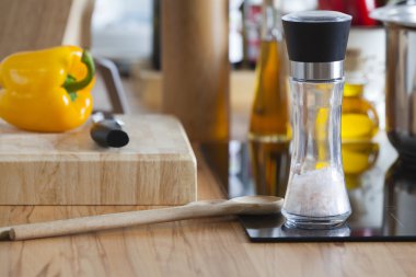 tuz değirmeni ve yemek kaşık modern seramik hob üzerinde bulunmaktadır