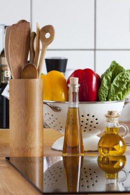 yemek kaşığı raf, sebze ve zeytinyağı tezgah üzerinde