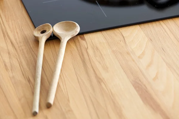 Dos cucharas de cocina se encuentra en la encimera cerca de placa de cerámica —  Fotos de Stock