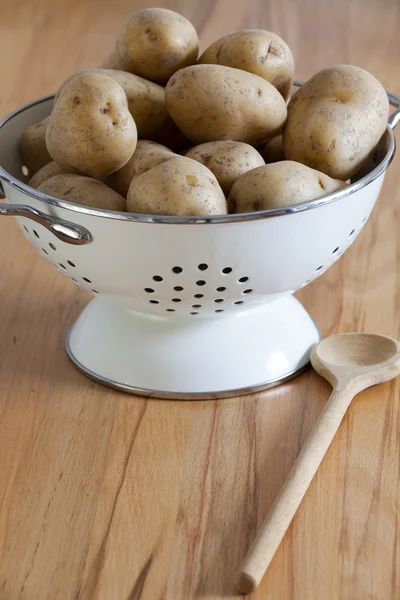 Λευκό σμάλτο σουρωτήρι με πρώτων πατάτες — Φωτογραφία Αρχείου