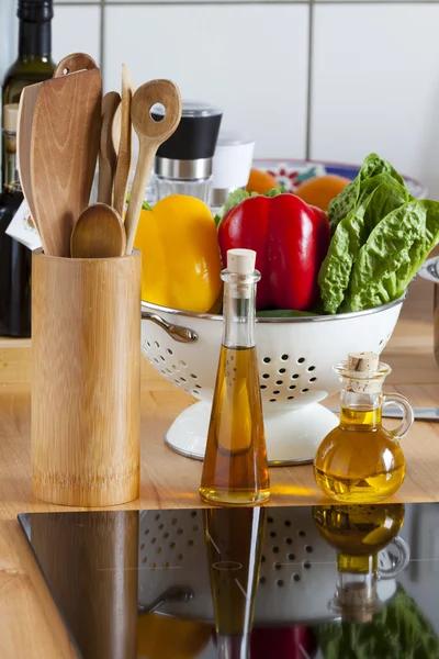 Cucchiaio, verdure e olio d'oliva sul piano di lavoro — Foto Stock