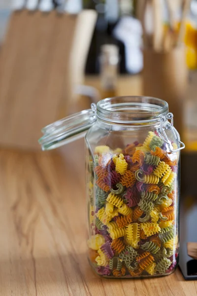 Open Storage Jar with colorful Pasta on Worktop — Stock Photo, Image
