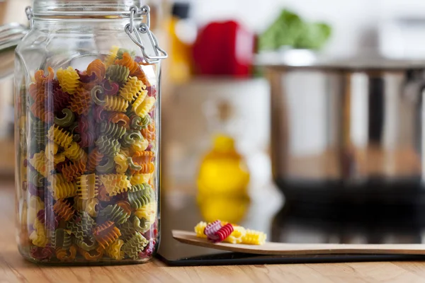 Close-up van een open opslag pot met kleurrijke pasta — Stockfoto