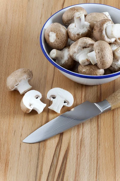 Fresh mushrooms in a bowl with a kitchen knife — Stock Photo, Image