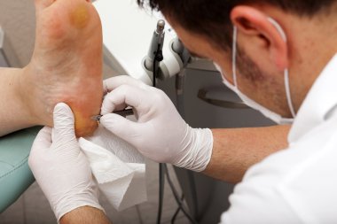 Chiropodists working with a scalpel clipart