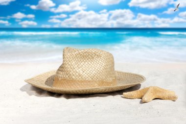Hasır şapka ve sahilde deniz yıldızı