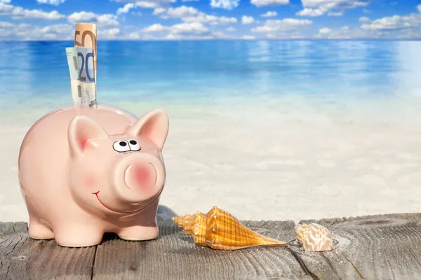 Piggy Bank com notas na praia — Fotografia de Stock