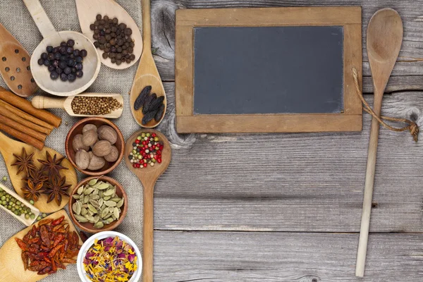 Spices on rustic wooden board with chalkboard — Stock Photo, Image