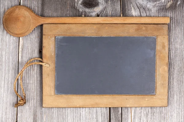 Zeer oude leisteen schoolbord en houten lepel — Stockfoto