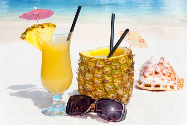Pineapple fruit and juice on the beach — Stock Photo, Image