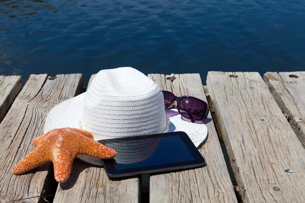 Tablet pc i słomy kapelusz na jezioro — Zdjęcie stockowe