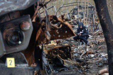 Bir polis memuru Ukrayna 'daki Rus ordusunun savaş suçlarını Ukrayna' nın Kyiv bölgesinde Rus ve Ukrayna orduları arasında yakın tarihli bir çatışmanın yaşandığı bölgede belgeliyor. 21 Nisan 2022.