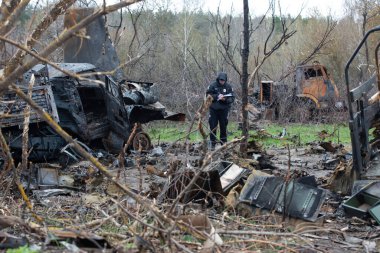 Bir polis memuru Ukrayna 'daki Rus ordusunun savaş suçlarını Ukrayna' nın Kyiv bölgesinde Rus ve Ukrayna orduları arasında yakın tarihli bir çatışmanın yaşandığı bölgede belgeliyor. 21 Nisan 2022.