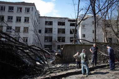 Toplum çalışanları, Rusya 'nın Ukrayna' nın Ukrayna 'nın Kyiv kentinde işgali sırasında bir hava saldırısında imha edilen askeri tesisin etrafındaki bir bölgeyi temizliyorlar. 29 Nisan 2022.